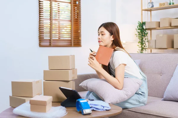 Online merchant concept, Female entrepreneur relaxes after packaging product into parcel boxes.