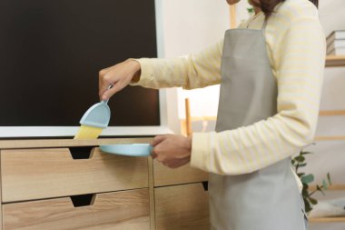 Temizlikçi süpürge ve faraş ile toz süpürme mobilya temizleme ve evde ev işi yaparken.