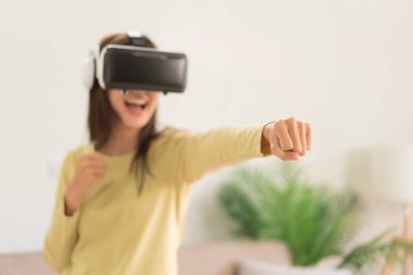 Evde faaliyet kavramı, gözlüklü sanal oyun oynamak için boks yapan genç bir kadın..