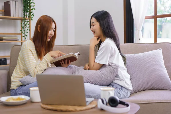 Activity at home concept, LGBT lesbian female is reading holy bible to girlfriend in living room.