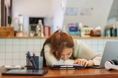Uzaktan çalışma kavramı, iş yerinde çalışmaktan yorulduktan sonra masada uyuyan kadın girişimci..