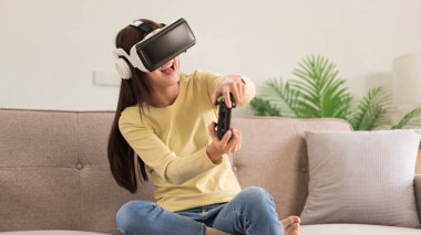 Relaxation concept, Young woman in VR glasses and controls the joystick to playing exciting games.