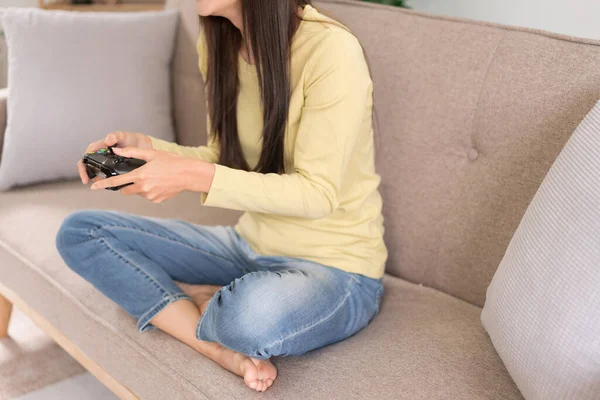 stock image Relaxation concept, Young woman sitting on the couch to playing video games with joystick console.