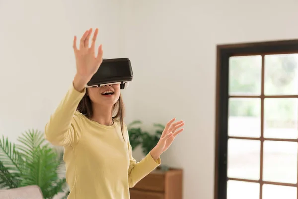 Leisure activities concept, Young woman touching the air to experience the virtual with glasses VR.