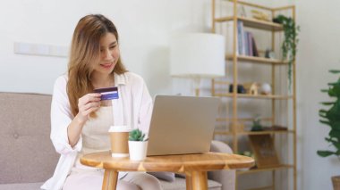 Ev konsepti ile ilgili çalışmalar, İş kadını dizüstü bilgisayarına kredi kartı verileri yazarak online alışveriş yapıyor.