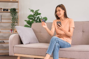Rahatlama konsepti, genç kadın online alışveriş için akıllı telefon ve kredi kartı kullanıyor.