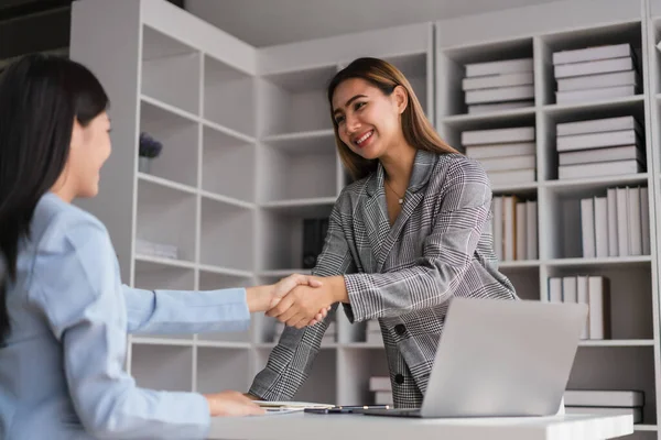 stock image Two businesswoman shaking hands after discussion about new business project and deal together.