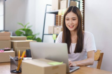 Çevrimiçi satış kavramı, Asyalı iş kadınları teslimatı hazırlamak için online siparişleri kontrol ediyorlar.