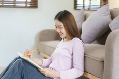 Kadınlar iş planlarını düşünür ve evde yerde otururken notlar yazarlar..