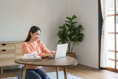 Yerlerde oturan ve iş verilerini bilgisayarda evde yaşam tarzında yazan kadınlar..