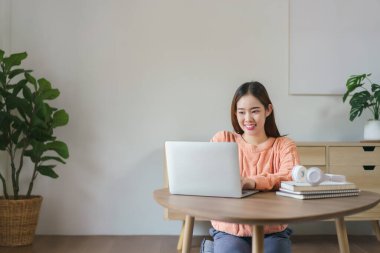 Yerlerde oturan ve iş verilerini bilgisayarda evde yaşam tarzında yazan kadınlar..