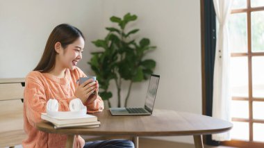 Kadınlar kahve içmek ve finans çizelgelerini evde dizüstü bilgisayarlarında okumak için yerde oturuyorlar..