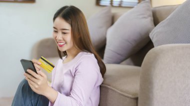 Kadınlar internet üzerinden alışveriş yaparken akıllı telefon ve kredi kartı kullanırlar..