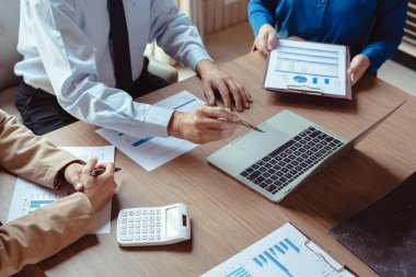 Bir grup iş arkadaşı yeni işletmelerin finansmanı ve pazarlanması hakkında fikir alışverişinde bulunuyor..