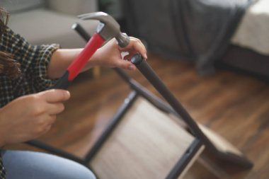 Kadınlar yeni ev için mobilya yaparken sandalye montajı ve onarımı için çekiç teçhizatı kullanıyorlar.