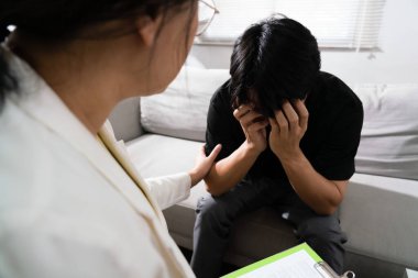 Psikolog kadın terapi merkezinde depresyondaki adamı cesaretlendiriyor..
