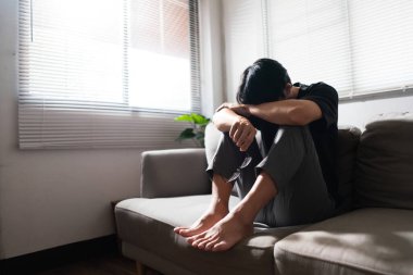 Zihinsel sağlık sorunu olan bir adam koltukta oturup depresyondaki duygularıyla kafasını dinlendiriyor..