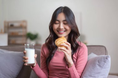 Kadınlar kanepede süt içmek ve evde sağlıklı yemekle ekmek yemek için boş vakitlerinde otururlar..