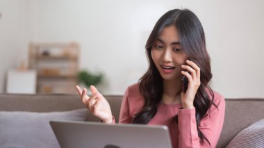 İş arkadaşlarıyla konuşmak için akıllı telefon kullanan ve evdeki yaşam tarzında dizüstü bilgisayarla çalışan kadınlar..