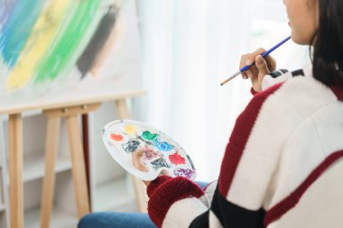 Sanat konsepti, Asyalı kadın ressamın tuvalin önünde oturup sanat eserleri yaratmayı düşünmesi..