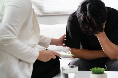 Psikolog kadın terapi merkezinde depresyondaki adamı cesaretlendiriyor..