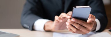 İş adamının verileri araştırmak ve başlangıç stratejisini analiz etmek için akıllı telefonu kullandığı yakın çekim elleri.