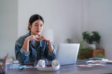 Grafik tasarımcı kadınlar grafik tasarımı hakkında düşünmek ve tasarlamak için dizüstü bilgisayarda veri okurlar.