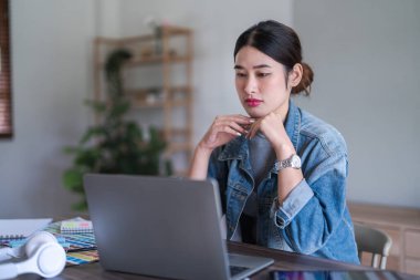 Grafik tasarımcı kadınlar grafik tasarımı hakkında düşünmek ve tasarlamak için dizüstü bilgisayarda veri okurlar.