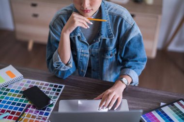 Dizüstü bilgisayardaki verileri ve grafik tasarımı hakkındaki analizleri araştıran grafik tasarımcı kadınlar.