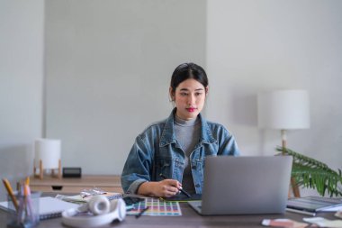 Grafik tasarımcı kadınlar grafik tasarımı hakkında tasarım yapmak için dizüstü bilgisayar ve dijital tabletle çalışıyorlar.