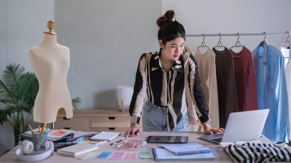 stock image Fashion designer women reading data on laptop to work designing clothes for creative new collection.