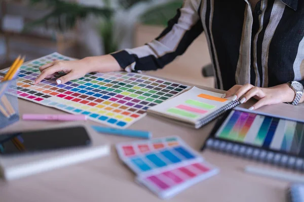 グラフィックデザイナーの女性は 色のサンプルと作業ブランドのグラフィックデザインの色を選択します ロイヤリティフリーのストック写真