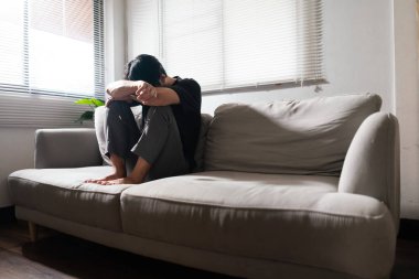 Zihinsel sağlık sorunu olan bir adam koltukta oturup depresyondaki duygularıyla kafasını dinlendiriyor..