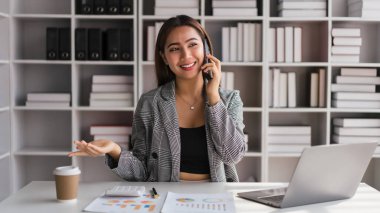 İş kadını, yeni iş projesiyle ilgili verileri açıklamaya akıllı telefondan iş arkadaşıyla konuşuyor.