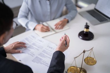 İş adamı belge okuyup iş verilerini avukata açıklarken, kadın avukat da hukuk firmasında yasal anlaşma ve iş sözleşmesinin şartları hakkında bilgi ve istişarede bulunuyor..