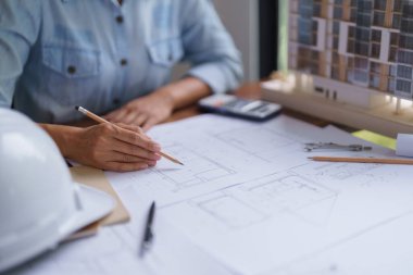 Mimar kadın inşaat mimari planıyla ilgili proje üzerinde çalışıyor..