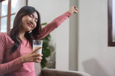 Kadınlar sabahları evlerinde yaşam tarzlarıyla uyanıp esnemek ve süt içmek için kanepede otururlar..