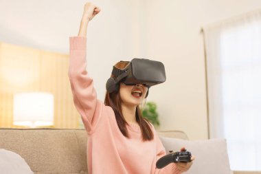 Ev konseptinde yaşam tarzı, LGBT lezbiyen kadınlar joystick ile oyun oynuyor ve kazanan jest yapıyor.