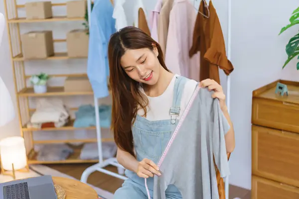 Fashion blogger concept, Young Asian women is selling and present clothes detail on video streaming.