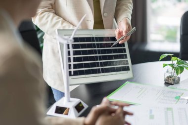 Alternatif enerji ortamı işadamları güneş pili paneli ve yenilenebilir enerji hakkında açıklama yapıyor.
