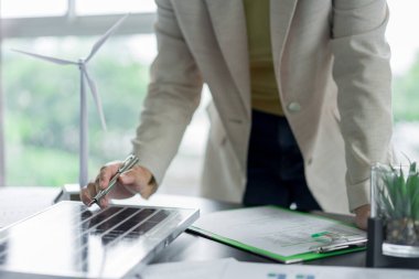 Alternatif enerji ortamı iş kadını güneş pili panelini kontrol etmeye çalışıyor..