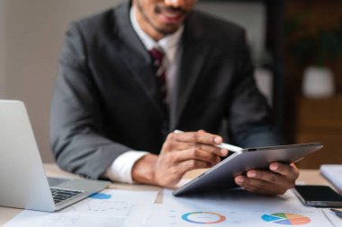 Girişim projesinin stratejisini analiz ederken, iş adamı tablet üzerine iş verileri yazıyor.