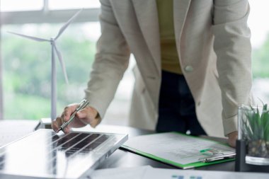 Alternatif enerji ortamı iş kadını güneş pili panelini kontrol etmeye çalışıyor..