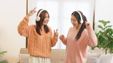 Ev konseptinde yaşam tarzı, LGBT lezbiyen çifti müzik dinlemek ve dans etmek için kulaklık takıyor.