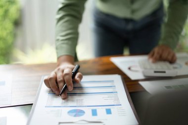 Kadın muhasebeci finans belgesini kontrol ediyor ve işletmelerin finansmanı için kar hesaplıyor.