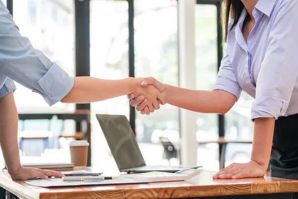 ビジネスのマーケティング戦略に関するコラボレーションの後 握手をする2人のビジネス女性 ストックフォト