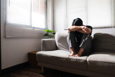 Zihinsel sağlık sorunu olan bir adam koltukta oturup depresyondaki duygularıyla kafasını dinlendiriyor..