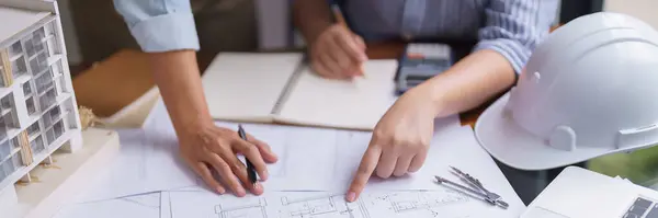 Two Architects Discuss Building Project Blueprint Construction Plan Taking Notes Стокове Зображення