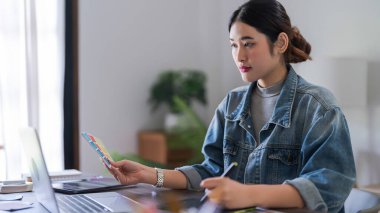 Grafik tasarımcı kadınlar dijital tablet üzerinde çalışırken grafik tasarımı için renk seçimi yapıyorlar.