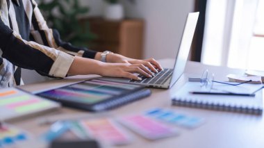 Grafik tasarımcı kadınlar teknolojiyle grafik tasarımı hakkında çalışırken dizüstü bilgisayarda veri yazıyorlar..